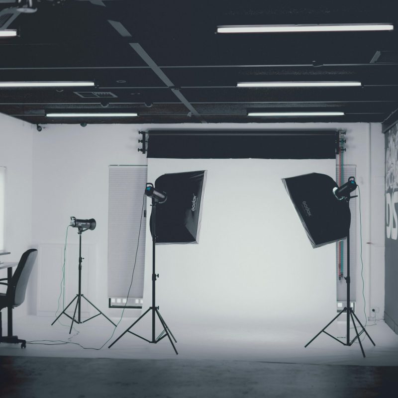 Wyposażenie Modern photo studio in grayscale with softbox lighting. Ideal for portrait and product photography.
