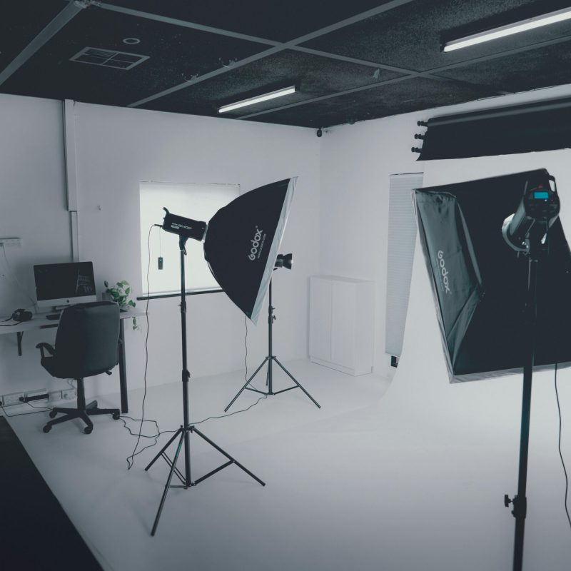 Wyposażenie A modern photography studio with professional lighting equipment and a computer workstation.
